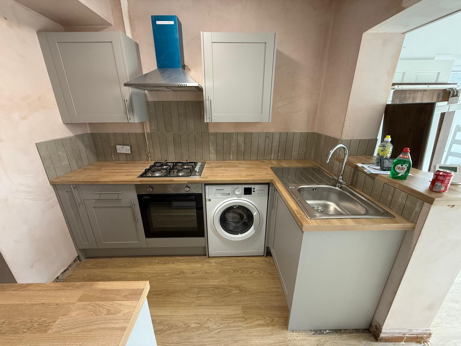 Completed rental kitchen with new units, oak worktops and tiled splashback