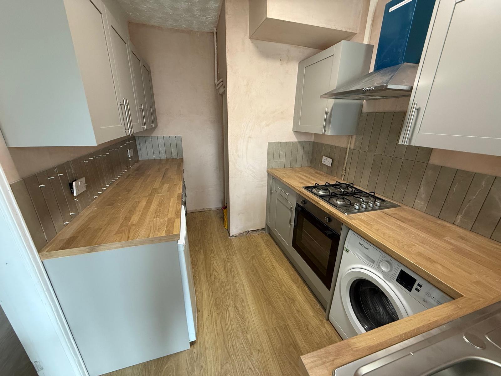 Kitchen mid-refurbishment with fresh plaster and new units being fitted
